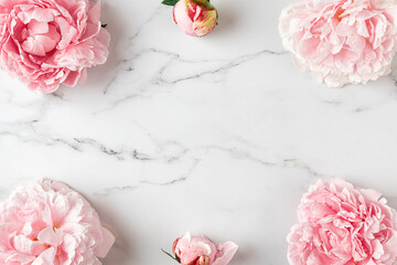 Flower composition. Frame made of pink peony flowers on white marble background. Flat lay. Top...