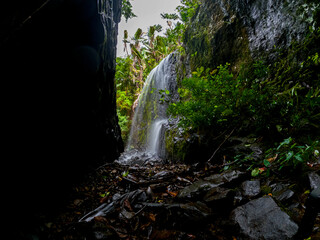 View of a waterfall from a cave hidden in Mauritius island