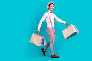 Full length photo of funny man dressed cap pants on suspenders go to empty space with new clothes...
