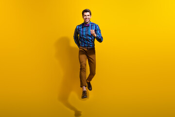 Fototapeta na wymiar Full body photo of active energetic optimistic man wear bow tie stylish shirt hurry running shopping isolated on yellow color background