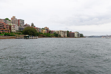 Fototapeta premium Sydney Harbour viewed from North Sydney with Sydney City Skyline and CBD high-rise, circular quay and Harbour Bridge. Cruise Liner Ship docked on wharf colourful skies NSW Australia