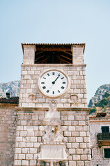 Fototapeta na wymiar Round clock on an ancient stone clocktower. Kotor, Montenegro