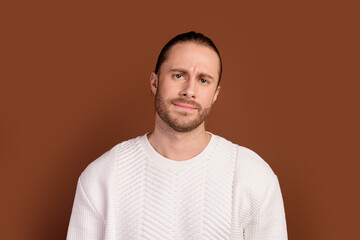 Photo of doubtful unsure man wear white sweater suspiciously looking you isolated brown color background