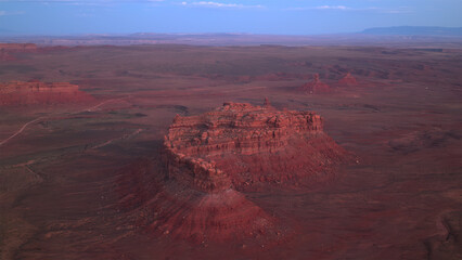 Aerial view of red rock mountain in desert at dusk