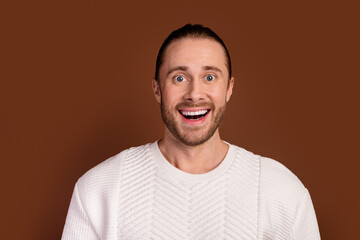 Fototapeta premium Photo of positive impressed man wear white sweater smiling open mouth isolated brown color background