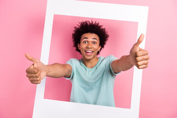 Photo portrait of nice young guy showing thumb up instant photo frame dressed stylish blue outfit isolated on pink color background