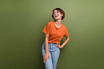 Photo of good mood girl with short hairdo dressed orange t-shirt in eyewear laughing look empty space isolated on green color background