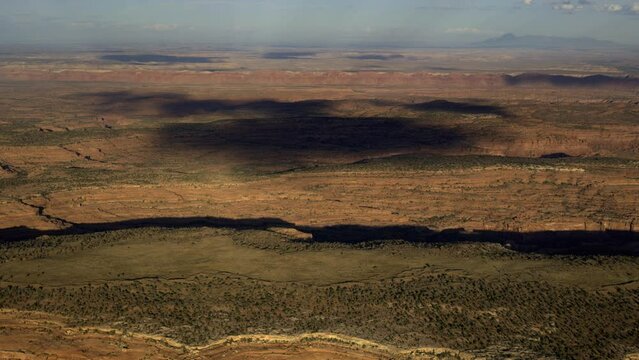 Aerial view of clouds casting shadows on desert landscape