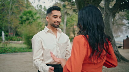 Beautiful hispanic couple performing energetic latino dance in park close up.