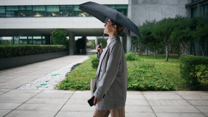 Office worker walking umbrella on rainy day. Confident businesswoman take break