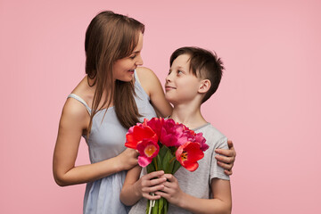 Mother looking at son with bouquet