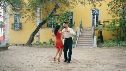 Couple dancers performing energetic dance on street. Sensual performers dancing.