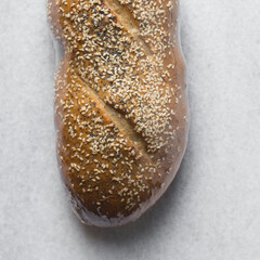 Top view of Bread loaf wrapped in plastic wrap on a marble countertop, loaf of bread wrapped in plastic film for freshness