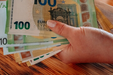 One hundred euro bills. Hands counting out euro money on the table.European Union money.euro...