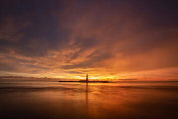 The scenery of the silhouette of Khao Lak lighthouse in sunset time with the dramatic twilight sky...