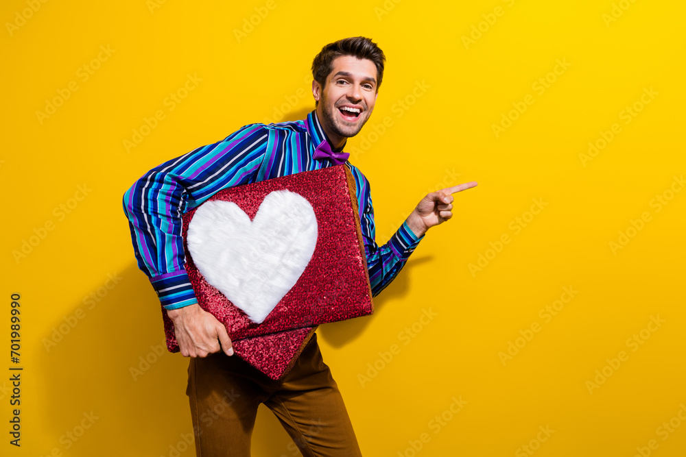 Poster portrait of nice guy dressed stylish shirt bow tie hold heart box directing at post empty space isol