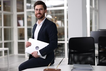 Portrait of smiling man with laptop in office, space for text. Lawyer, businessman, accountant or manager