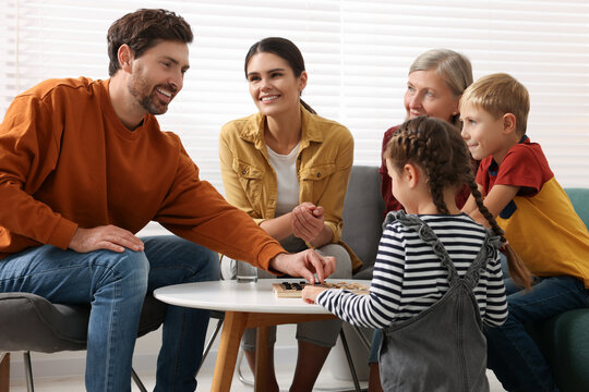 Family playing checkers at coffee table in room