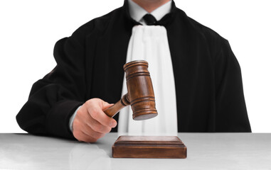 Judge with gavel at table on white background, closeup