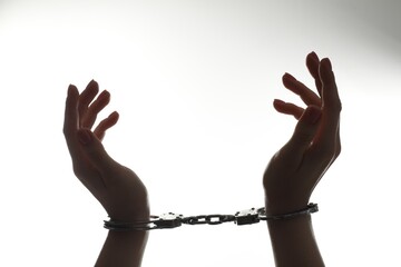 Freedom concept. Woman with handcuffs on white background, closeup