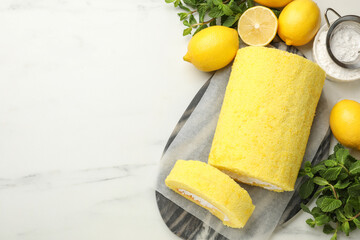 Delicious cake roll, lemons, mint and powdered sugar on white marble table, flat lay. Space for text