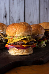 Homemade fresh meat burgers with potato bread with egg bacon tomato lettuce onion cheddar cheese ham dressings different varieties with fries fast food