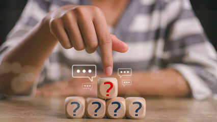 Businesswoman touching wooden arranging cube with question mark icon. Q and A concept. frequently...