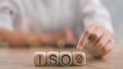 ISO quality control certification concept. Businesswomen press on the wooden cubes with the...