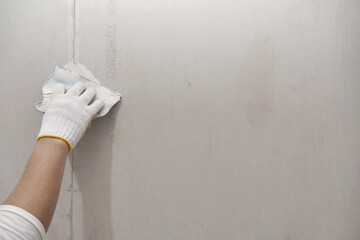 Plasterwork and wall painting preparation. close up hand of craftsman applying filling drywall...
