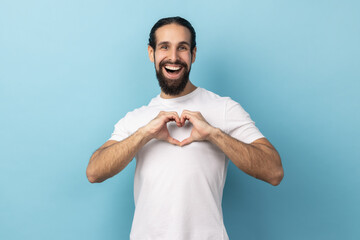I love you sign. Be my valentine. Portrait of romantic man with beard wearing white T-shirt shapes...