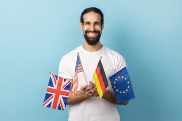 Portrait of extremely happy man with beard wearing white T-shirt standing holding in hands British,...