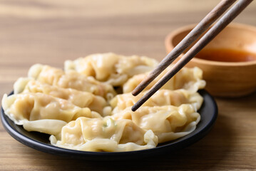 Steamed wonton dumpling stuffed with minced pork and chicken eating with sesame oil sauce