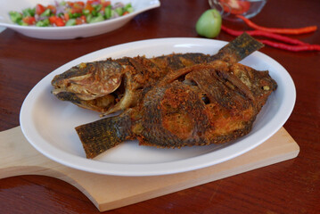 Fried Tilapia or Nila fish in a white plate