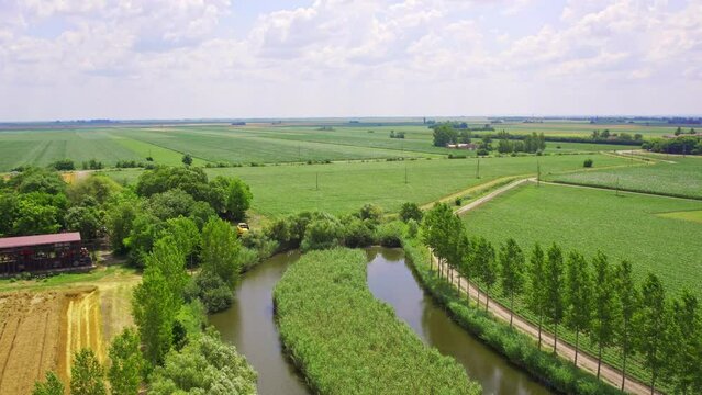 Aerial view of plain green countryside and a fish pond
