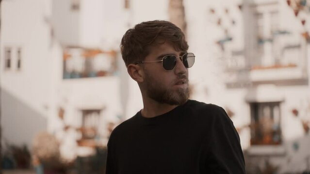 Modern hipster male smoking a cigarette and blowing the smoke into the street. Slow motion
