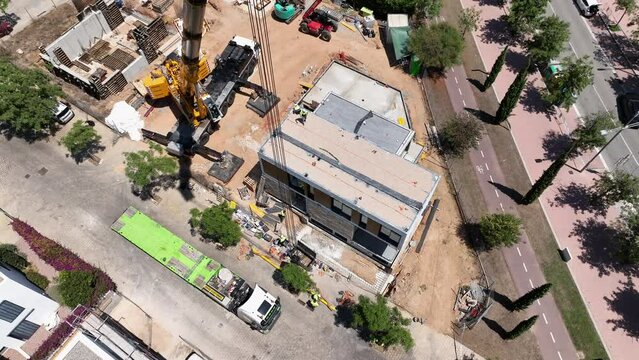 Pre-fabricated modular house construction site. Aerial top-down drone circling