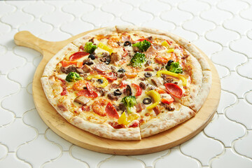 Combination pizza on wooden cutting board