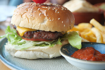 Cheeseburger With Salad And Tomato On a wooden board 