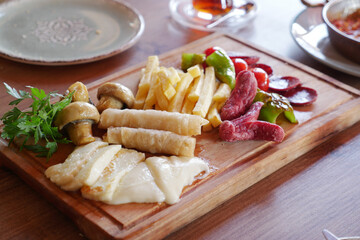  salami sausage, mushroom , tomato and french fries on a tray 