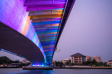 Beautiful multi-colored lights that light up the bridge over the river