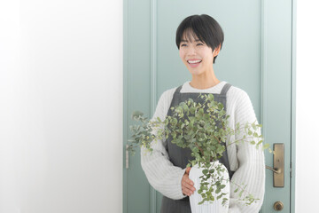 Image of a florist store salesman, customer service worker, or housewife holding a vase of flowers.