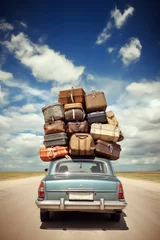 Foto op Canvas Travelling by car. Retro car with luggage on the roof. Car on the road with a lot of suitcases on roof. Family travel on vacation © Stavros