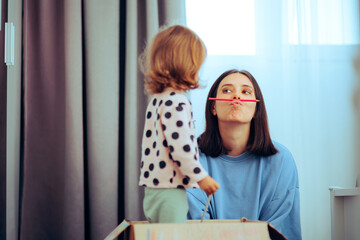 Funny mom Balancing a Crayon on her Lips Acting Silly. Comical Mother trying to make her kid laugh...