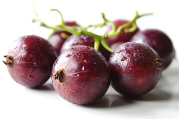Obraz premium A bunch of plums, professionally photographed, are displayed on a table, showcasing their fresh and vibrant color.