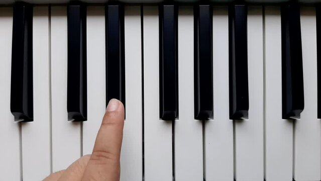 A beginner plays black keys on the piano