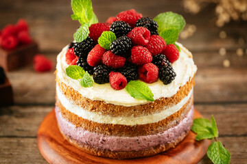 A homemade raspberry and blackberry cake decorated with fresh berries.