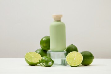 An unlabeled cosmetic bottle is placed on a glass podium with fresh lemons arranged around it. White background for cosmetics advertisement with copy space.