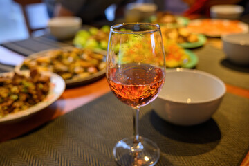 Drinks and dishes on the dinner table. Out-of-focus people around the table. Home cooking and entertainment for Christmas.