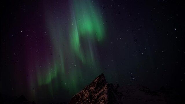 Dramatic Northern lights in the sky of the Lofoten Islands in Norway. Tilt Up