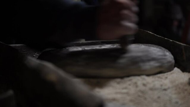Artisanal Milling: Hand-Turned Millstone Grinds Wheat, Craftsmanship, and Human Ingenuity in Traditional Stone Milling Process for Flour Production